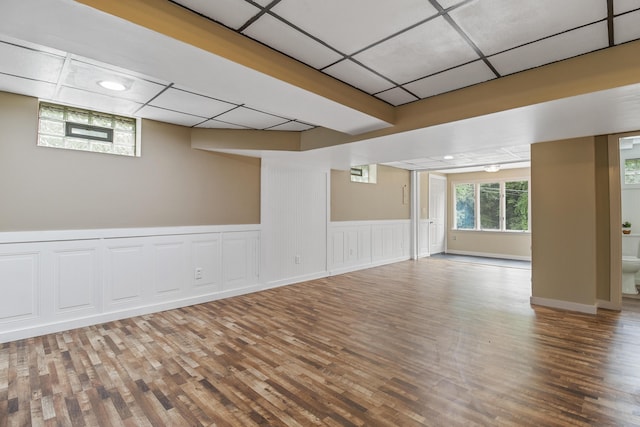 spare room with a paneled ceiling and hardwood / wood-style floors