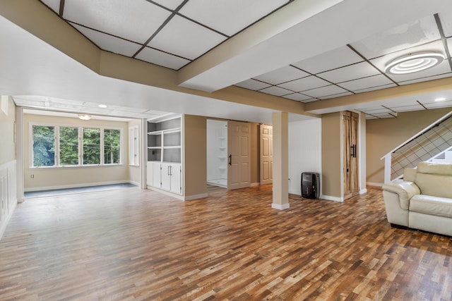 unfurnished living room with hardwood / wood-style flooring and a drop ceiling