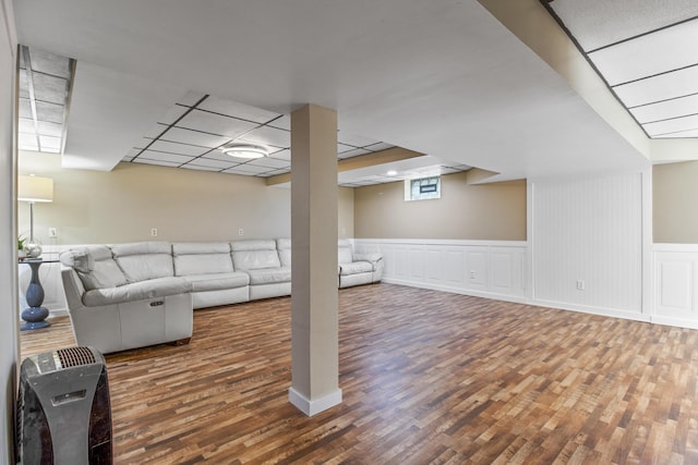 unfurnished living room with a drop ceiling and wood-type flooring