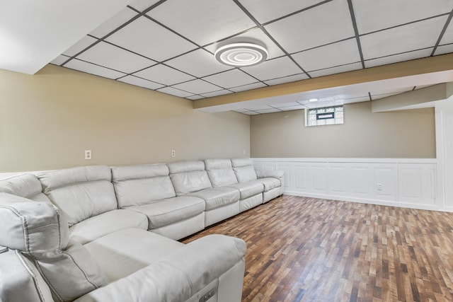 unfurnished living room with a drop ceiling and wood-type flooring