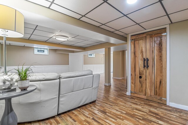 living room with a paneled ceiling and hardwood / wood-style floors