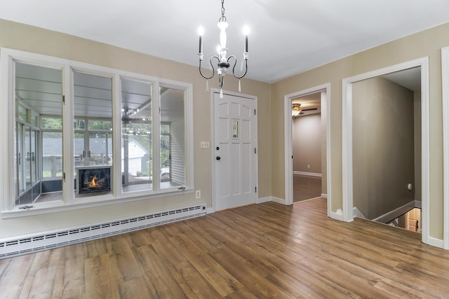 entrance foyer featuring wood-type flooring, a baseboard heating unit, and a notable chandelier