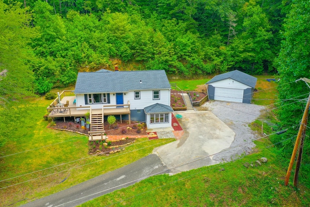 view of front of house with a deck, a front yard, a garage, and an outdoor structure