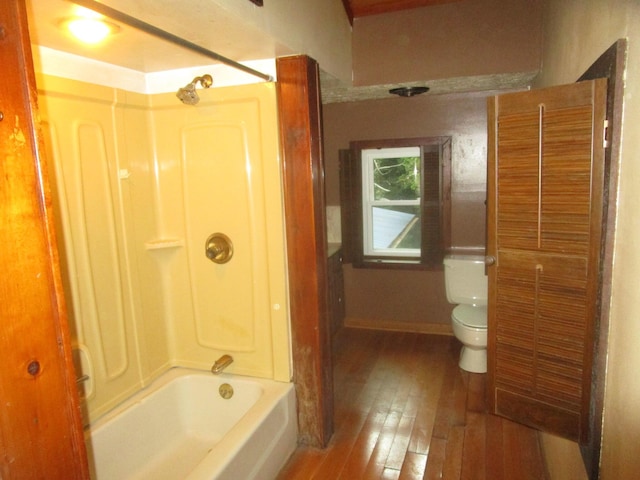 bathroom featuring hardwood / wood-style flooring,  shower combination, and toilet