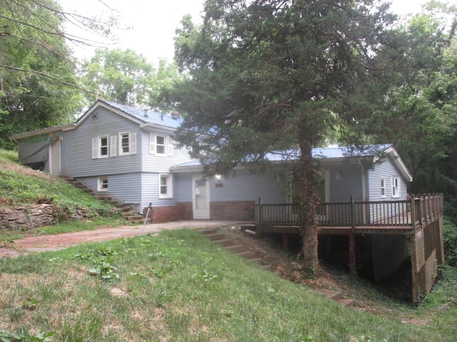 view of front facade with a front yard and a deck