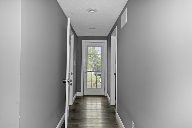 doorway featuring dark hardwood / wood-style floors and a textured ceiling