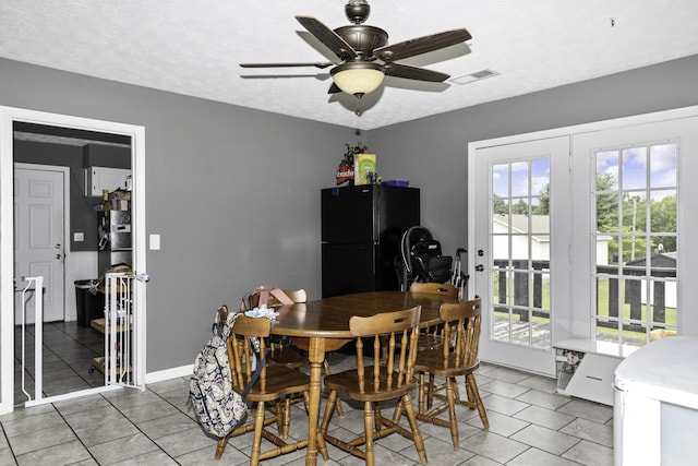 dining area featuring ceiling fan, tile patterned floors, and a textured ceiling