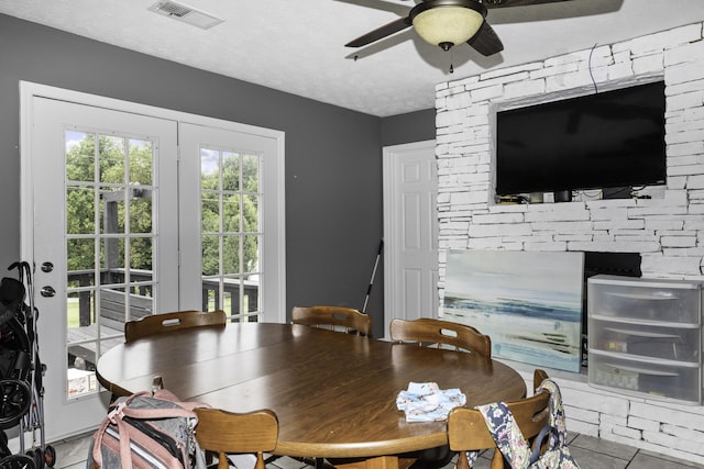 dining area featuring light tile patterned flooring, ceiling fan, and a textured ceiling