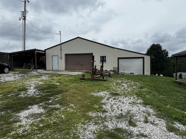 garage featuring a carport and a yard