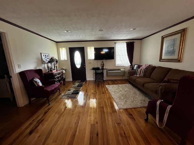 living room with hardwood / wood-style flooring, ornamental molding, and a textured ceiling