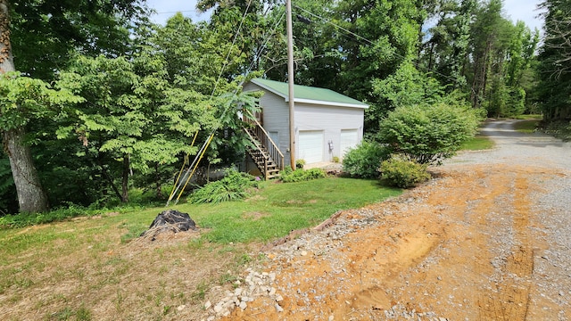 view of yard with a garage and an outbuilding