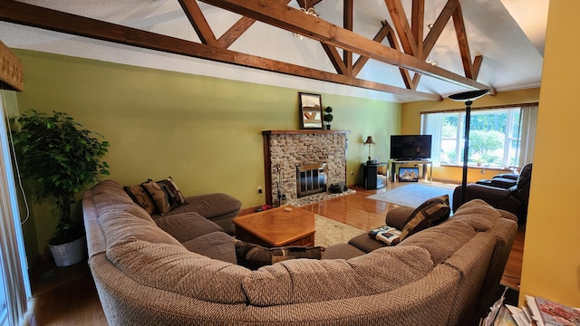 living room featuring beamed ceiling, a stone fireplace, and hardwood / wood-style flooring