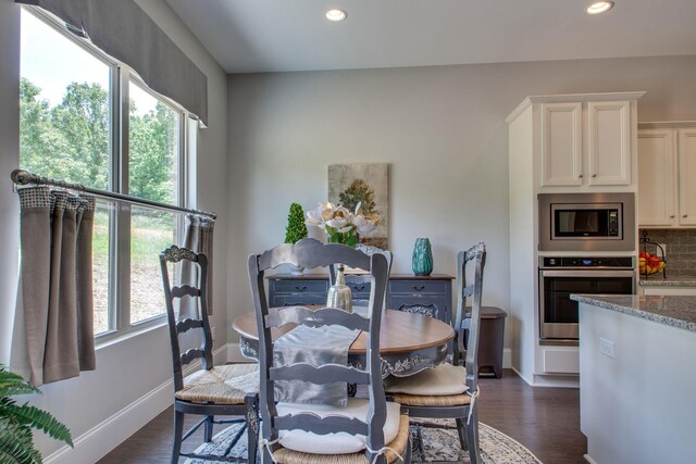 dining space with dark hardwood / wood-style flooring and a healthy amount of sunlight