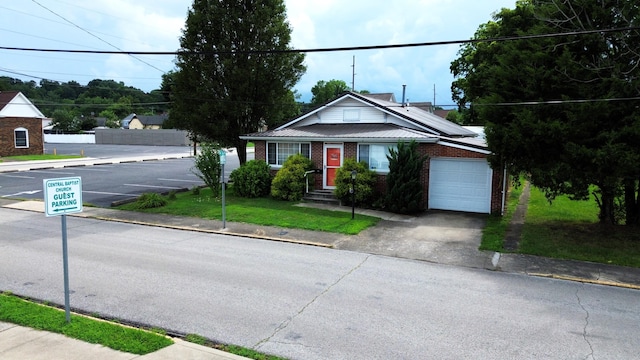 view of front of home with metal roof, brick siding, a front lawn, solar panels, and a garage
