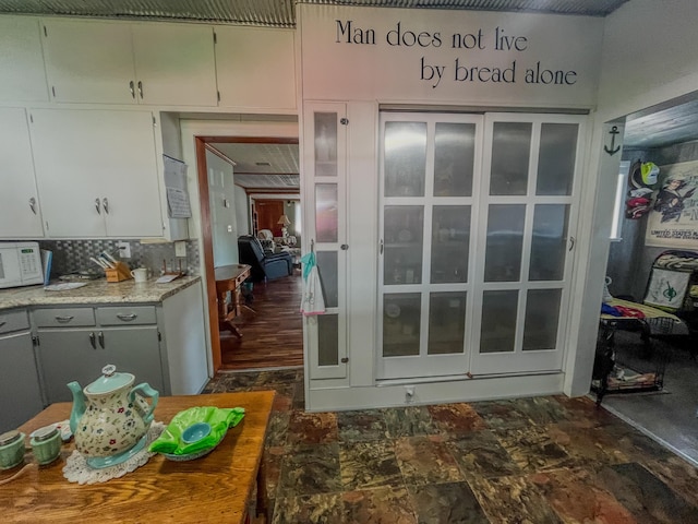 interior space with tasteful backsplash and white microwave