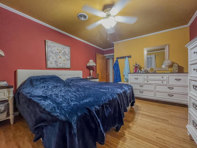 bedroom featuring visible vents, ceiling fan, ornamental molding, and wood finished floors