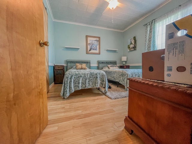 bedroom with a ceiling fan, wood finished floors, and ornamental molding