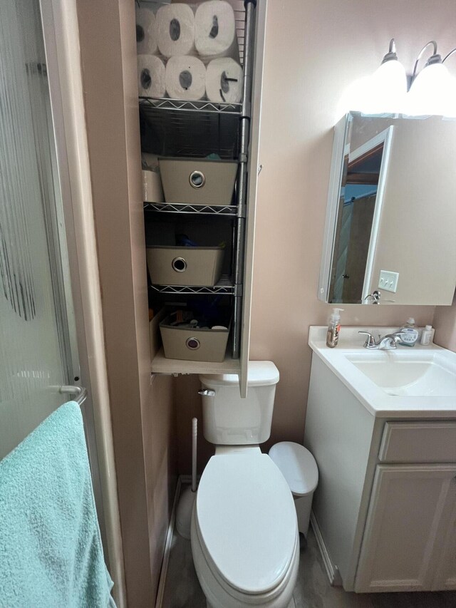 bathroom featuring toilet, vanity, and baseboards