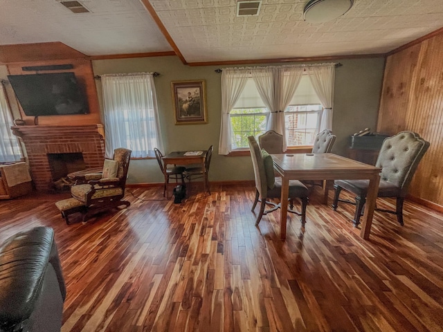 dining room featuring ornamental molding, baseboards, wood finished floors, and visible vents