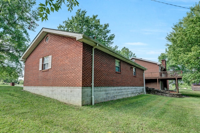 view of side of property with a wooden deck and a yard