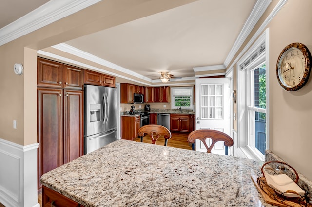 kitchen featuring plenty of natural light, ceiling fan, hardwood / wood-style floors, and stainless steel appliances