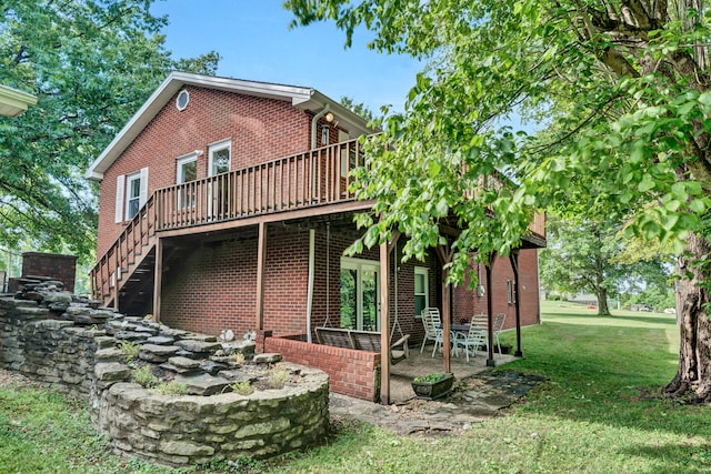 rear view of house featuring a deck, a patio area, and a yard