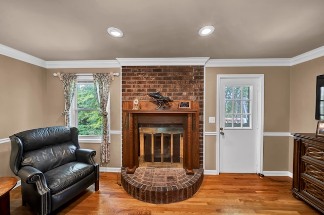 living room featuring a fireplace, light hardwood / wood-style floors, and ornamental molding