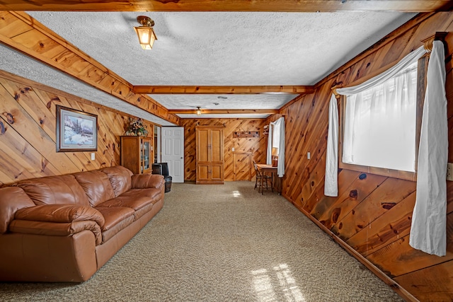 unfurnished living room with carpet flooring, beamed ceiling, wood walls, and a textured ceiling