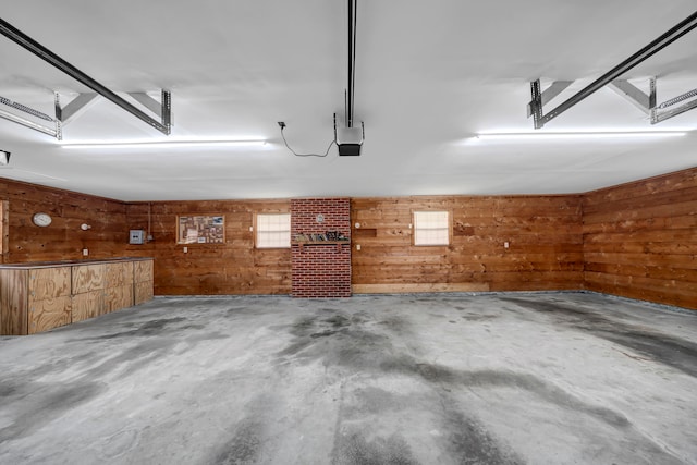 garage featuring a garage door opener and wooden walls