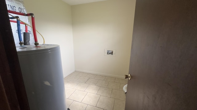 laundry area featuring gas water heater, washer hookup, and light tile patterned flooring