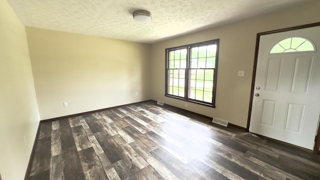 foyer with dark hardwood / wood-style floors and a textured ceiling