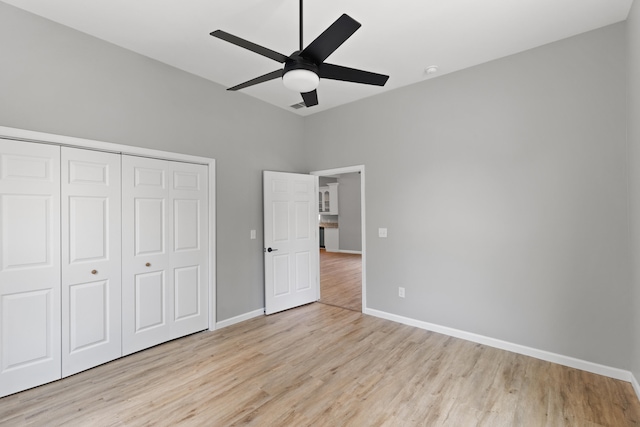 unfurnished bedroom featuring a closet, light hardwood / wood-style floors, and ceiling fan