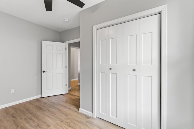 unfurnished bedroom featuring a closet, light wood-type flooring, and ceiling fan