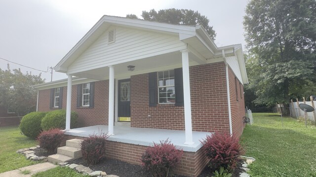 view of front of home featuring a porch and a front lawn