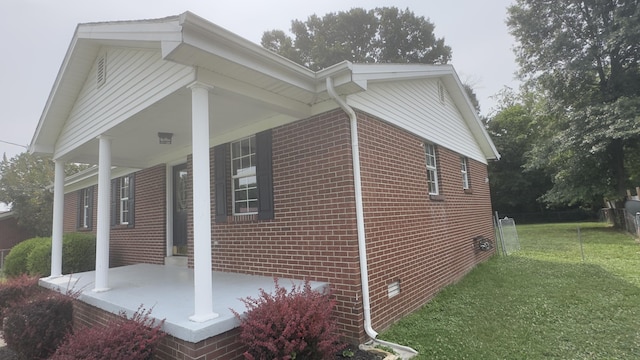 view of home's exterior with a porch and a lawn