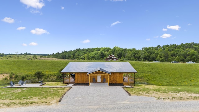 view of front of house with a front yard and a rural view