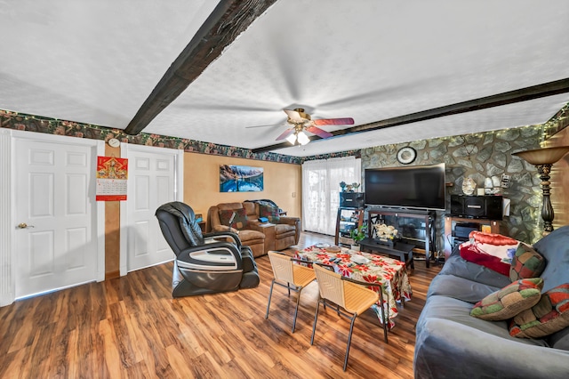 living room featuring hardwood / wood-style flooring, beamed ceiling, and ceiling fan