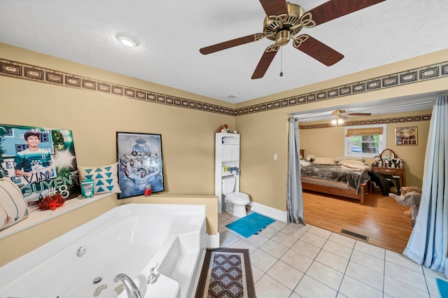 bathroom featuring a textured ceiling, ceiling fan, and tile patterned floors