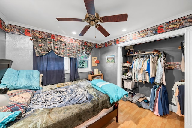 bedroom featuring crown molding, light hardwood / wood-style flooring, ceiling fan, and a closet