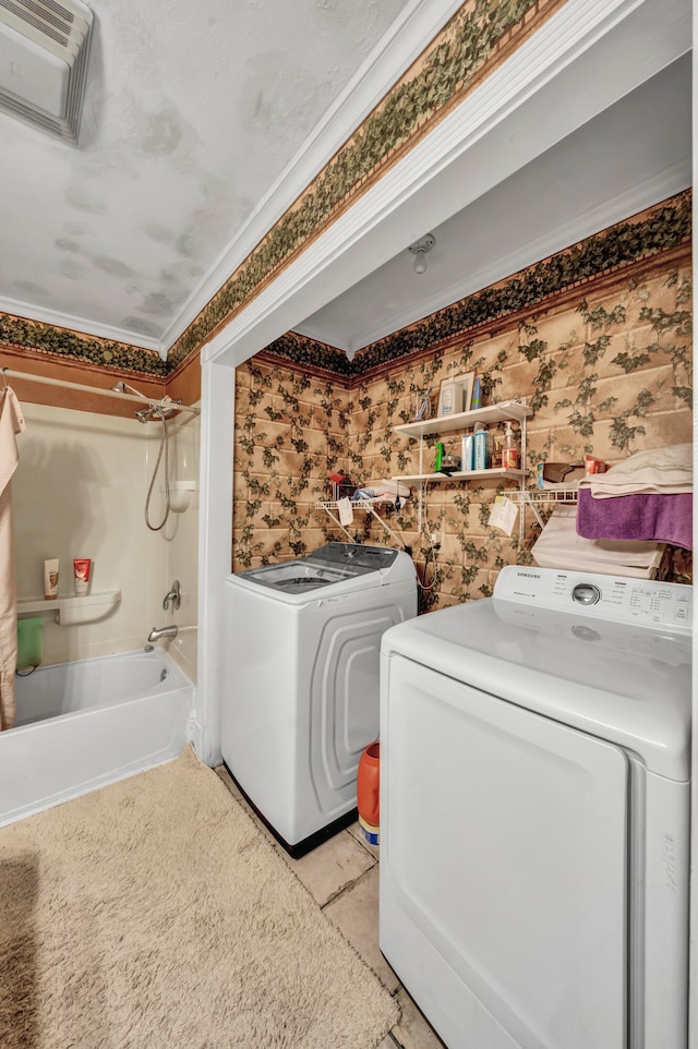 laundry area with washer and clothes dryer and light tile patterned floors