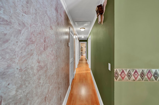 hallway featuring light hardwood / wood-style floors and crown molding