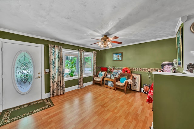 entryway with ceiling fan, wood-type flooring, and ornamental molding