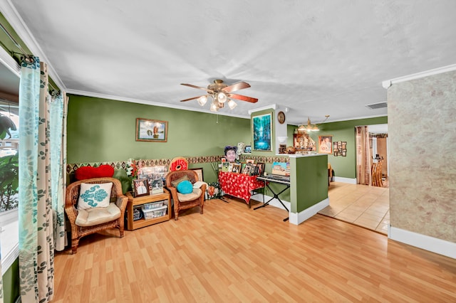 rec room with crown molding, light hardwood / wood-style flooring, and ceiling fan