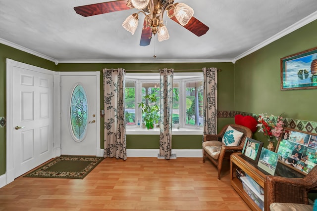 entrance foyer featuring light hardwood / wood-style flooring, ornamental molding, and ceiling fan