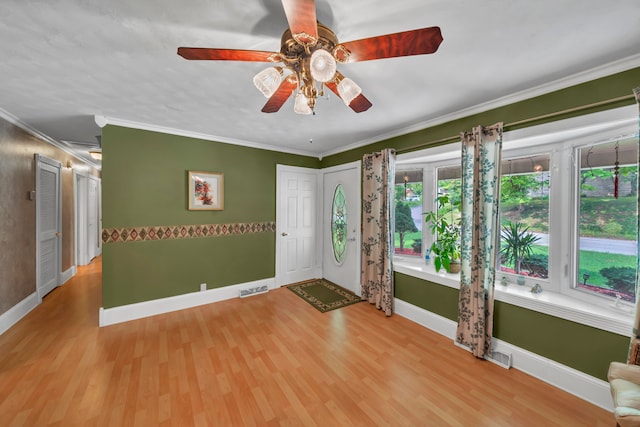 empty room with light hardwood / wood-style floors, ornamental molding, and ceiling fan