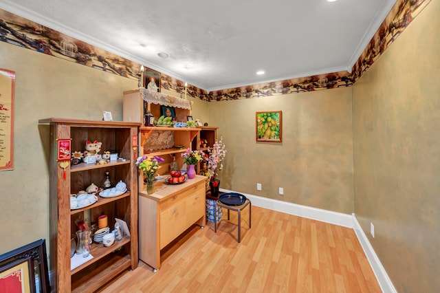 home office with light hardwood / wood-style flooring and crown molding