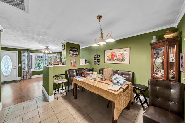 dining area featuring crown molding, ceiling fan with notable chandelier, and light tile patterned floors