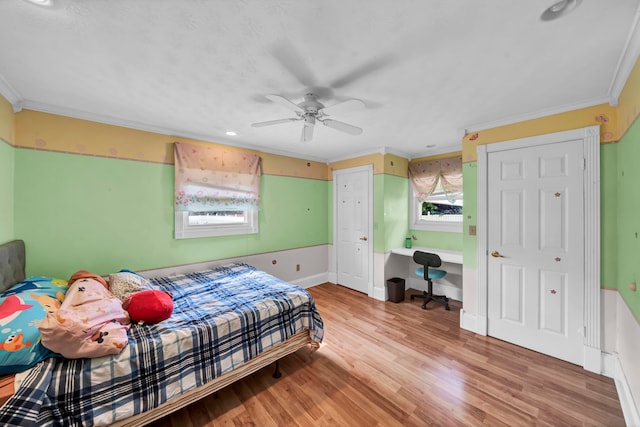 bedroom featuring light hardwood / wood-style floors, ornamental molding, and ceiling fan