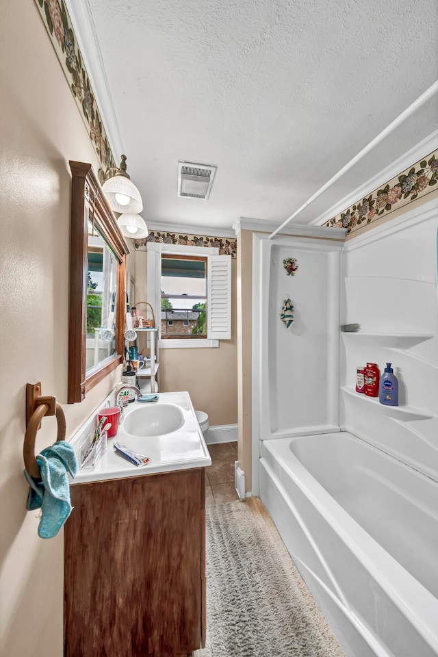 bathroom with tile patterned flooring, shower / tub combination, a textured ceiling, vanity, and ornamental molding