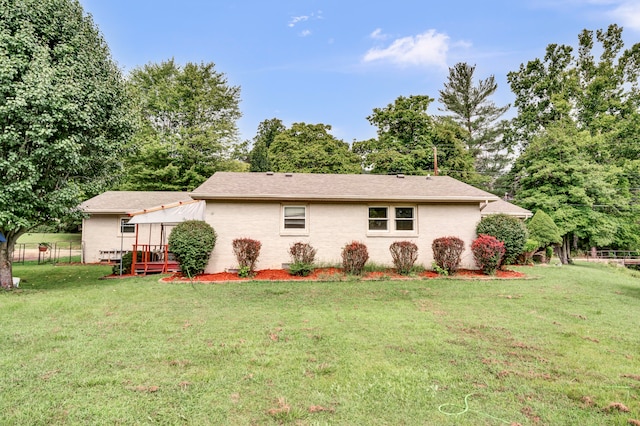 view of front of house with a wooden deck and a front yard